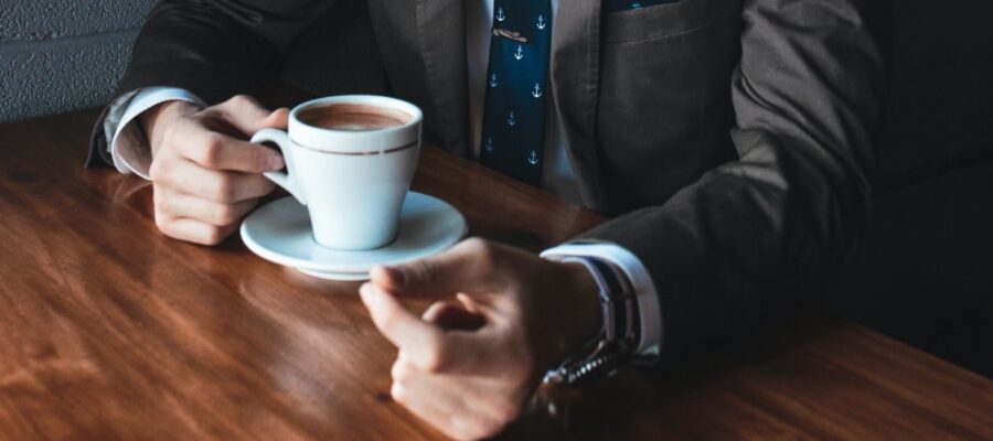 Man holds full cup of coffee