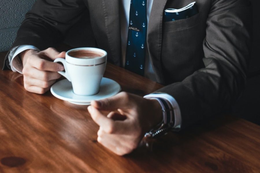 Man holds full cup of coffee