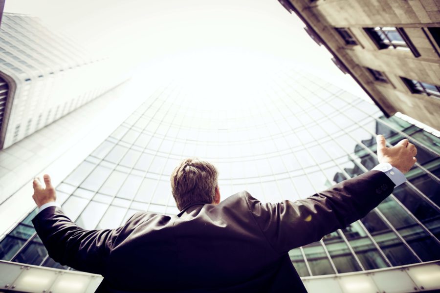 Ecstatic business man throwing his hands in the air