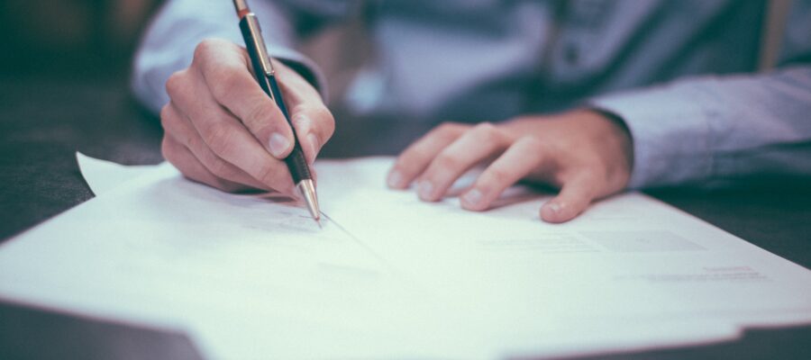 Hands signing a contract