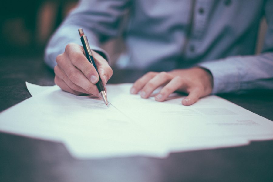 Hands signing a contract