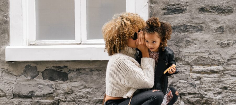 Mother whispering to her daughter