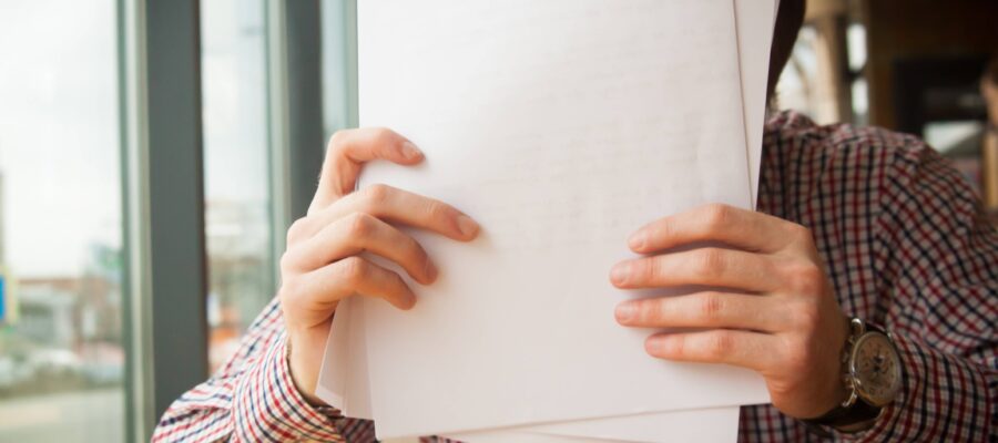Manholes papers in front of his face