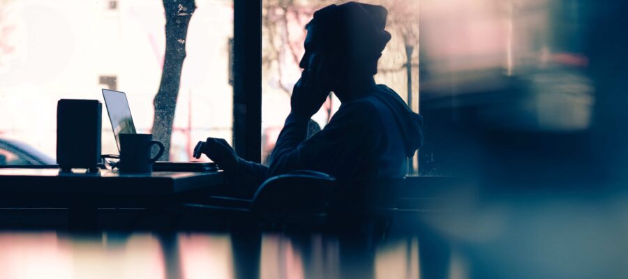 Silhouette young man on phone with laptop