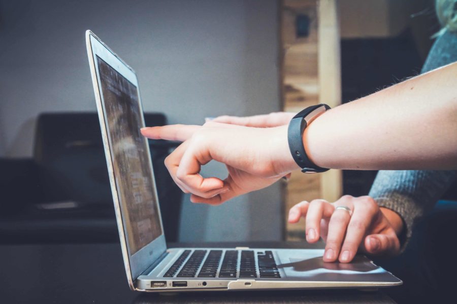 Hands pointing to a profit and loss statement on a screen